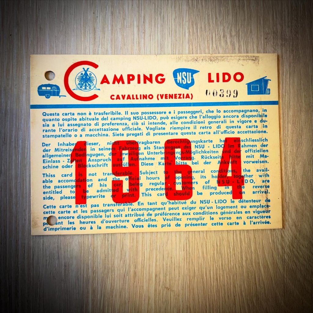 Historische Gästekarte des Camping NSU Lido in Cavallino (Venezia) aus dem Jahr 1964. Die mehrsprachige Berechtigungskarte ist für den Karteninhaber und die ihn begleitenden Personen bestimmt und bestätigt das Recht auf eine bevorzugte Aufnahme beim Camping NSU Lido im Rahmen der geltenden Bedingungen. Die Karte enthält italienische, deutsche, englische und französische Texte sowie das Logo des Camping NSU Lido und Abbildungen eines Caravans und eines Zeltes.