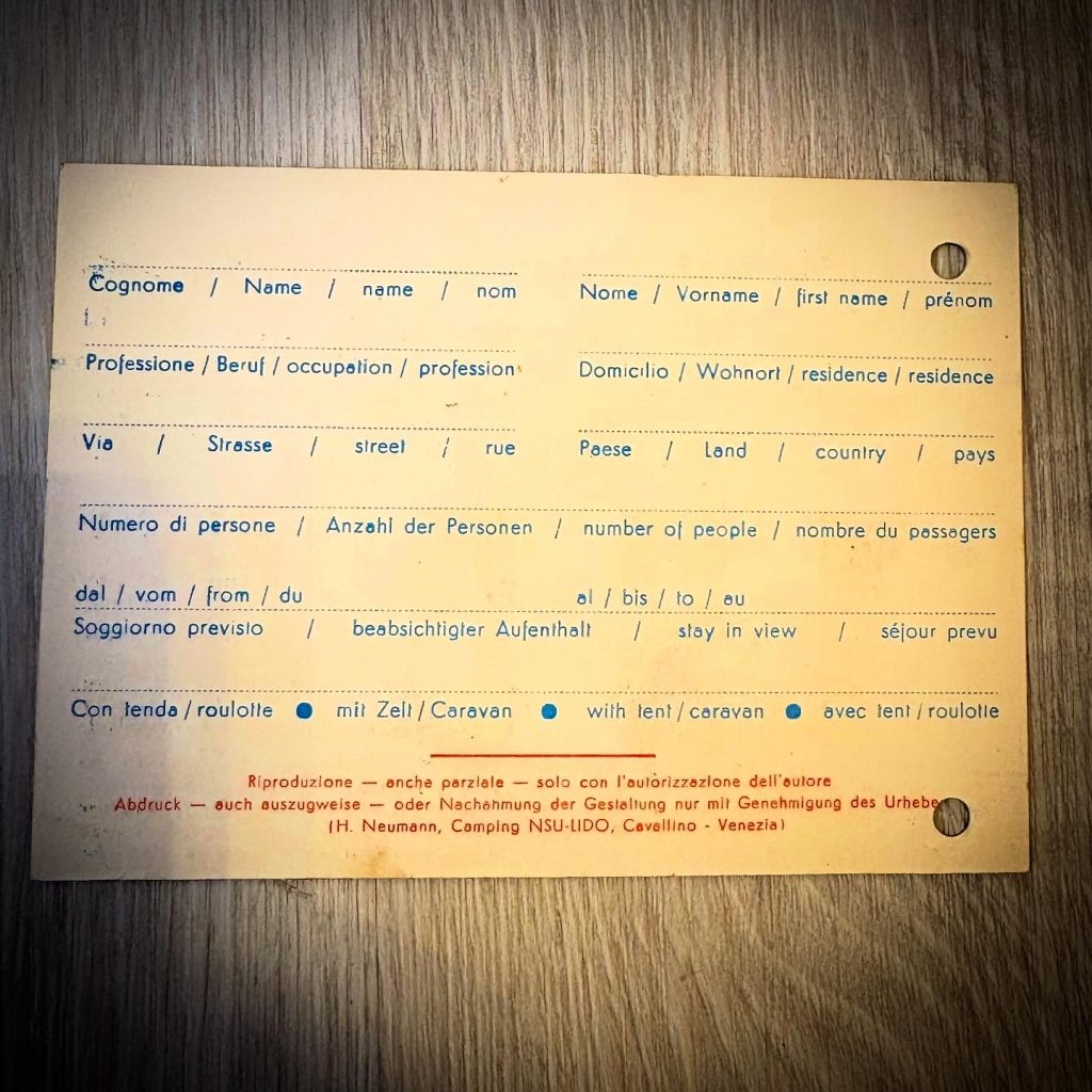 Rückseite einer historischen Gästekarte des Camping NSU Lido in Cavallino (Venezia) aus dem Jahr 1964. Die Karte enthält Felder für Nachname, Vorname, Beruf, Wohnort, Straße, Land, Anzahl der Personen und den vorgesehenen Aufenthaltszeitraum. Zusätzlich wird angegeben, ob der Aufenthalt mit Zelt oder Wohnwagen erfolgt. Die Angaben sind mehrsprachig in Italienisch, Deutsch, Englisch und Französisch ausgeführt.